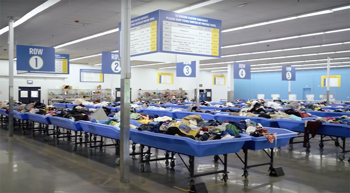 Rows of blue bins filled with clothing at Goodwill Kentucky
